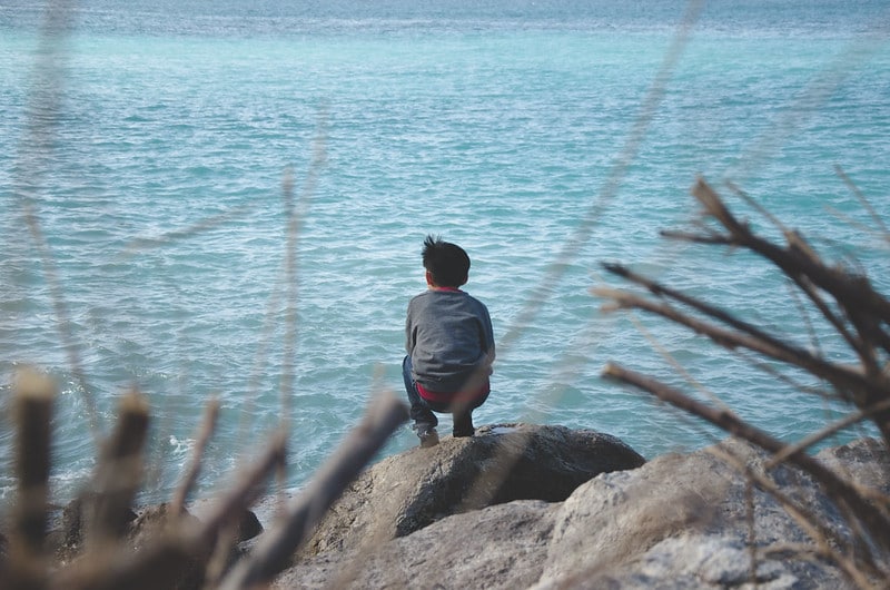 kid staring mindfully at water